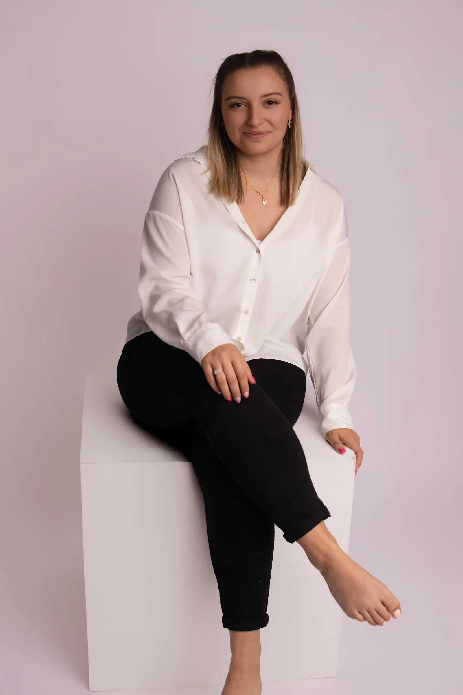 Portrait studio d'une femme en chemise blanche assise sur un cube, par Cindy Poulet Photographe à Septvaux.