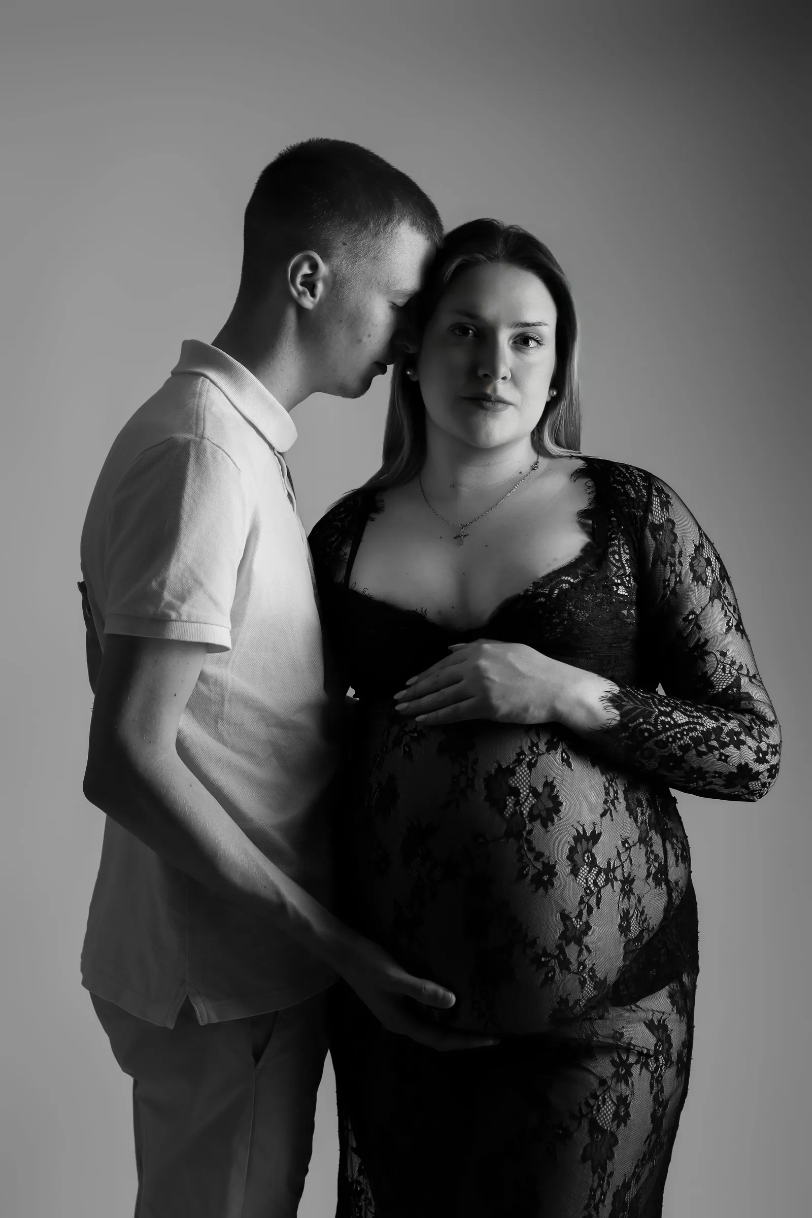Portrait artistique en noir et blanc d'un couple lors d'une séance photo de grossesse en studio, par Cindy Poulet Photographe