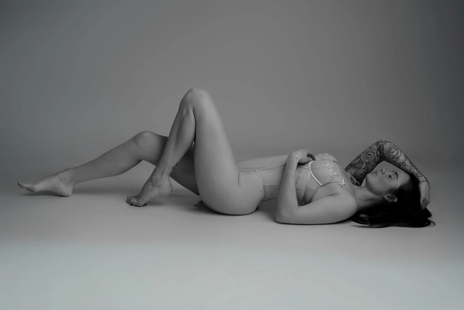 Femme allongée en sous-vêtements blancs sur fond gris, portrait artistique - Cindy Poulet photographe