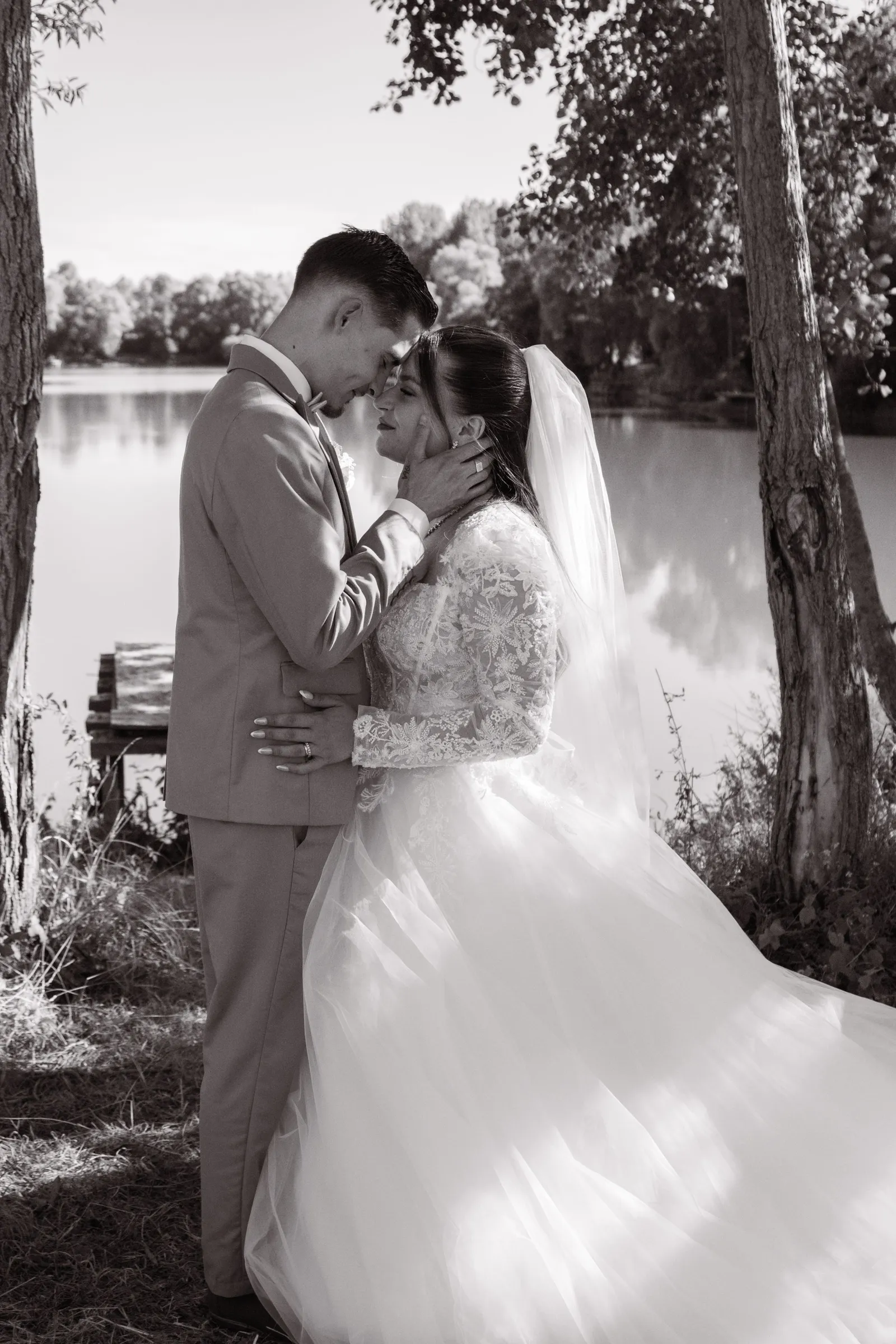 Couple de mariés enlacé au bord d'un plan d'eau, photo de mariage en noir et blanc - Cindy Poulet photographe