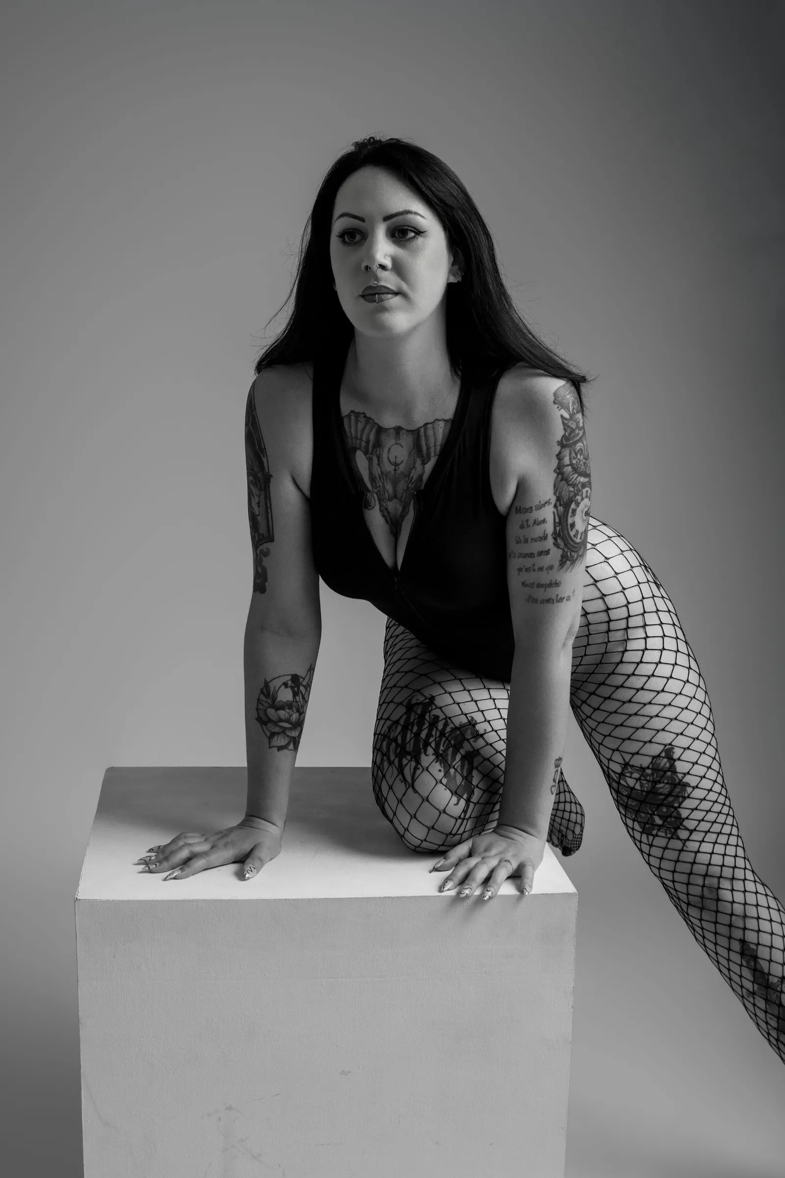 Femme en noir et blanc penchée vers un cube blanc, portrait boudoir - Cindy Poulet photographe