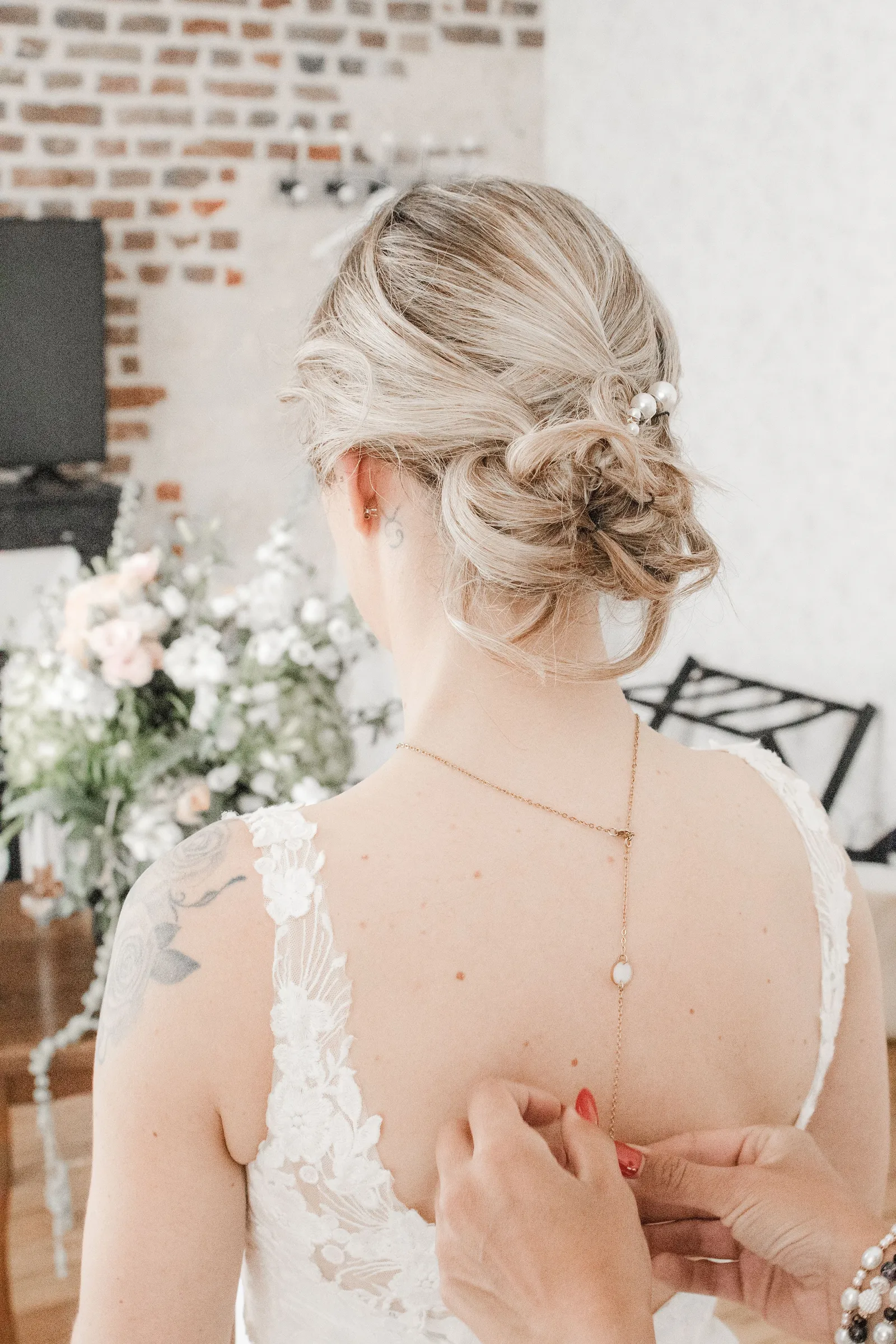 Mariée de dos coiffure élégante et robe dos nu, préparatifs mariage - Cindy Poulet photographe