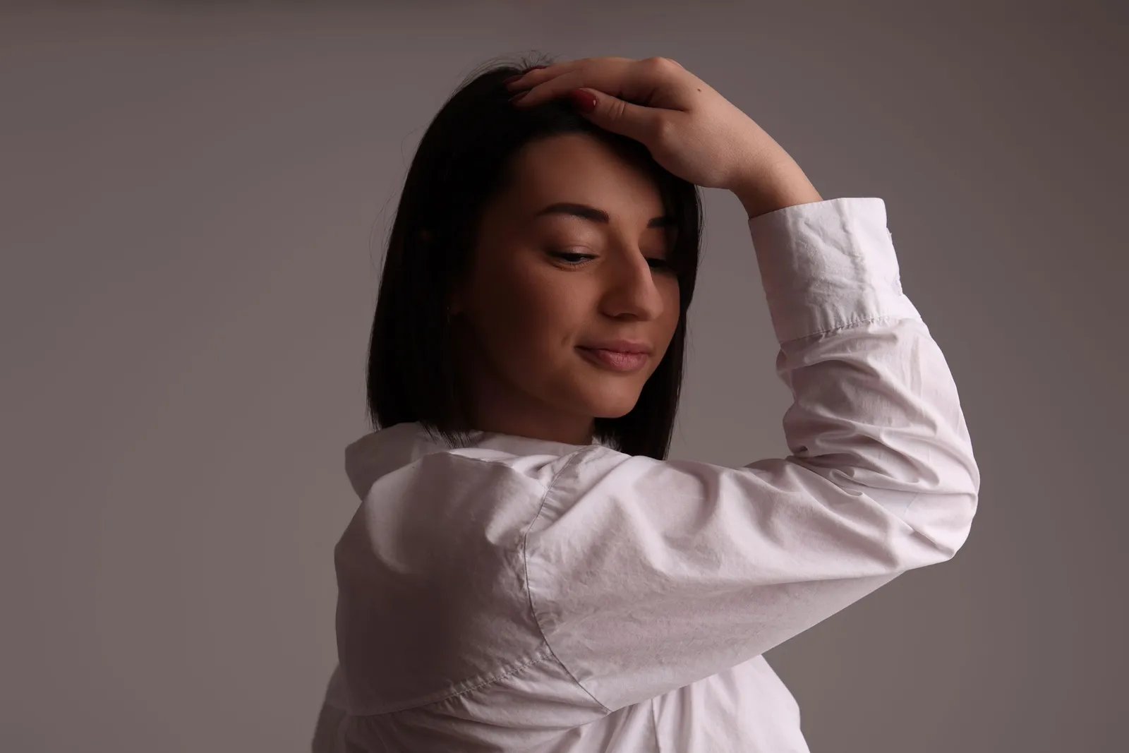 Femme en chemise blanche avec main sur la tête, portrait dynamique - Cindy Poulet photographe