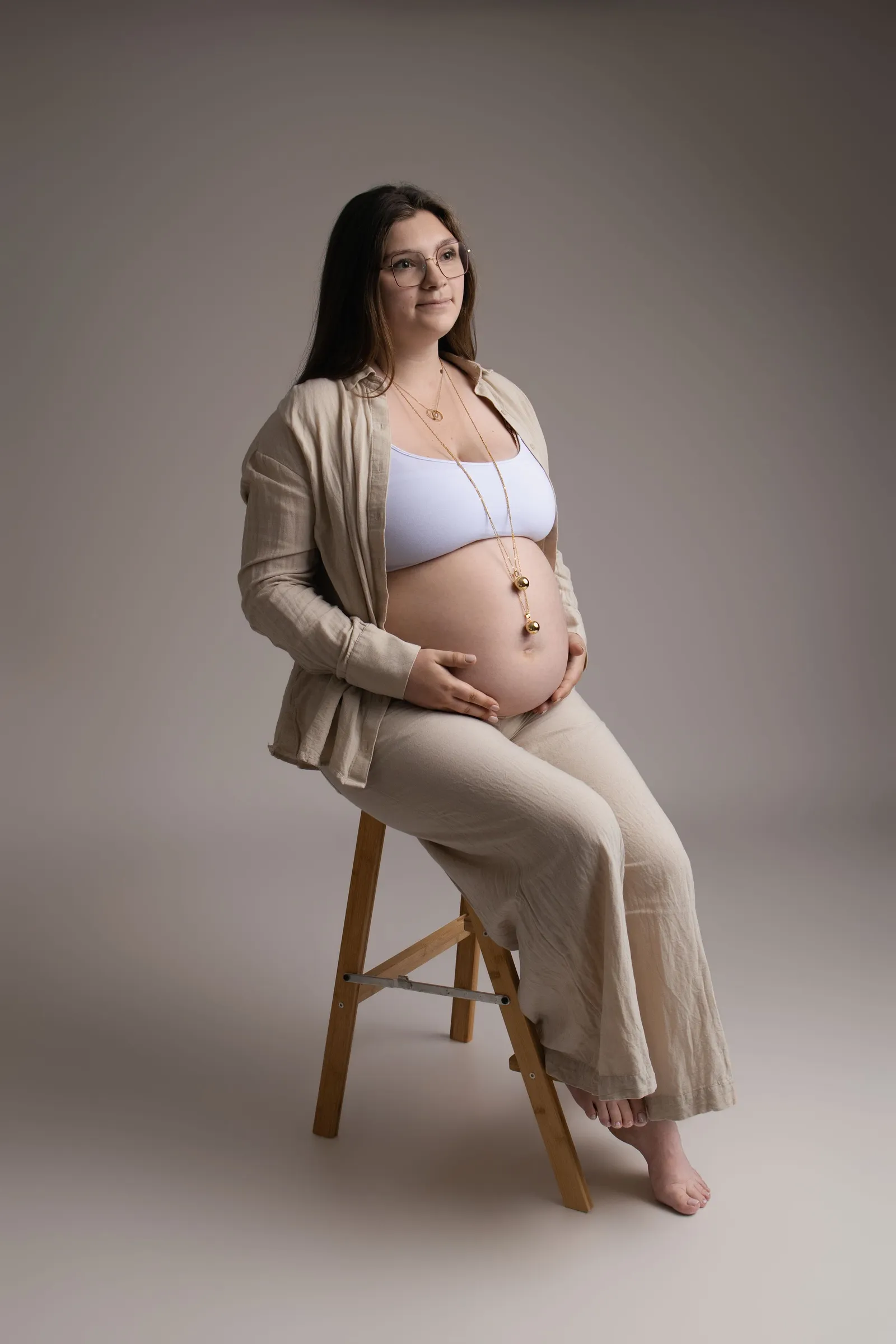 Femme enceinte en tenue posant seule en studio, portrait maternité élégant - Cindy Poulet photographe