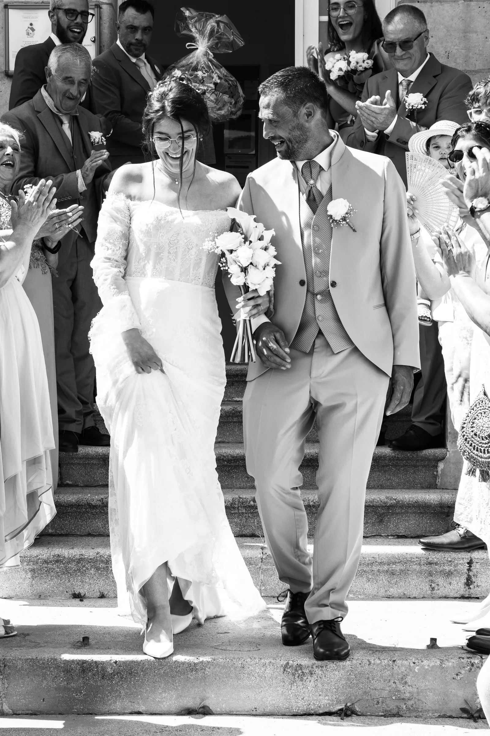 Sortie des mariés sous les applaudissements des invités, escalier en noir et blanc - Cindy Poulet photographe