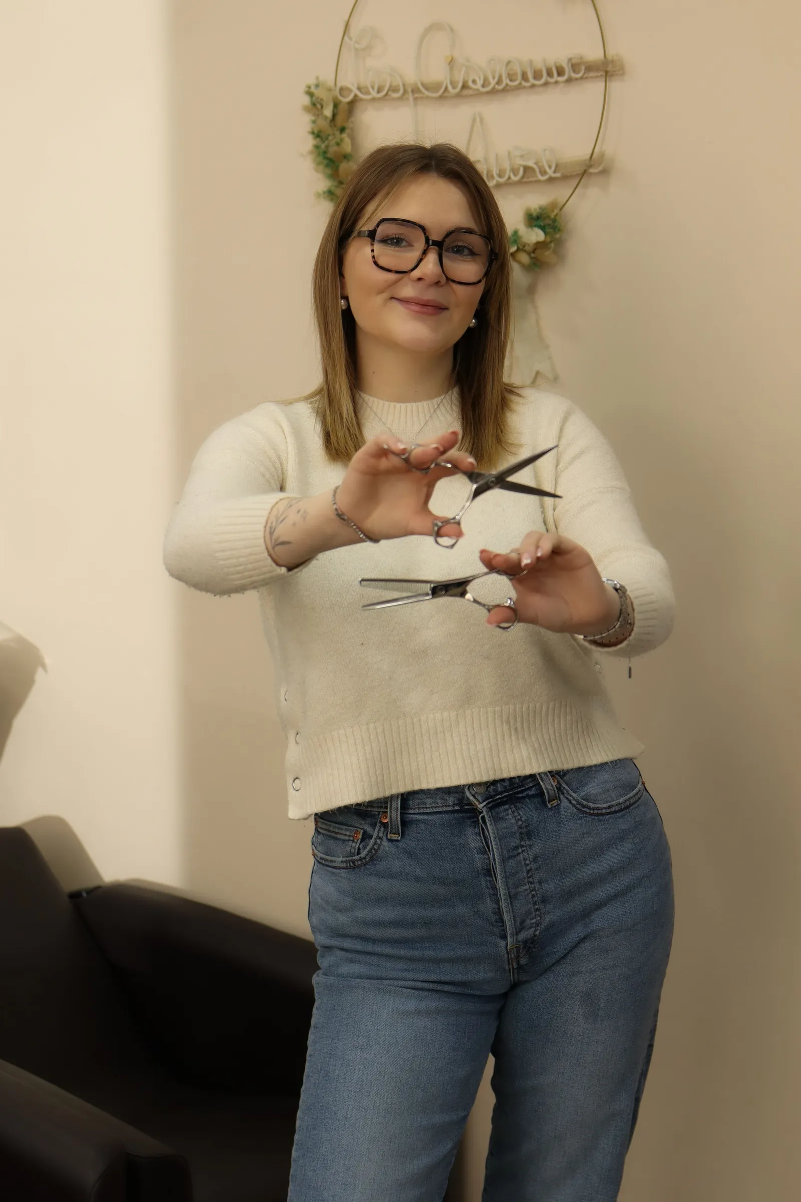 Portrait d'une coiffeuse souriante tenant ses ciseaux, par Cindy Poulet Photographe proche Laon.