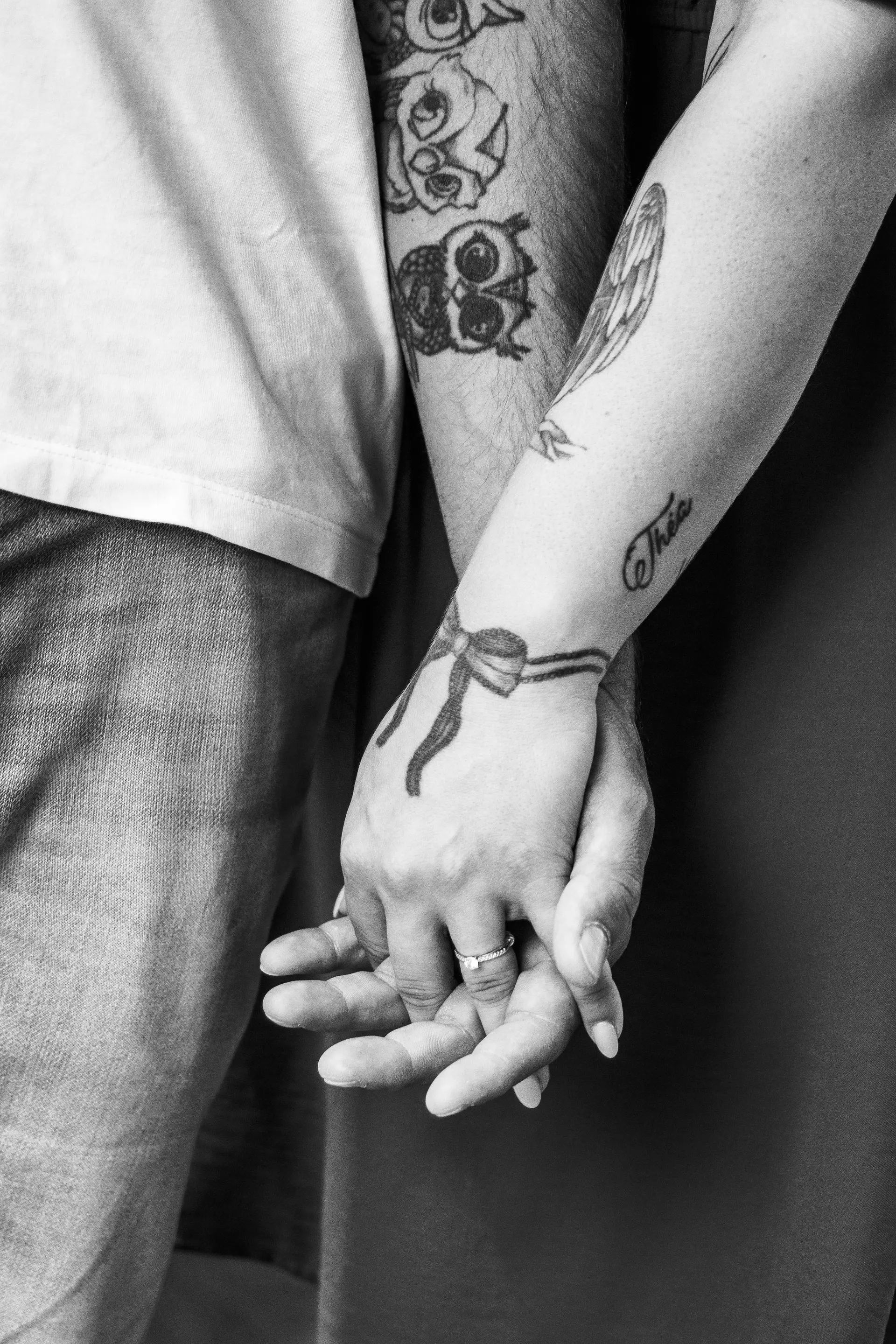 Mains des mariés entrelacées, alliances et tatouages en noir et blanc - Cindy Poulet photographe