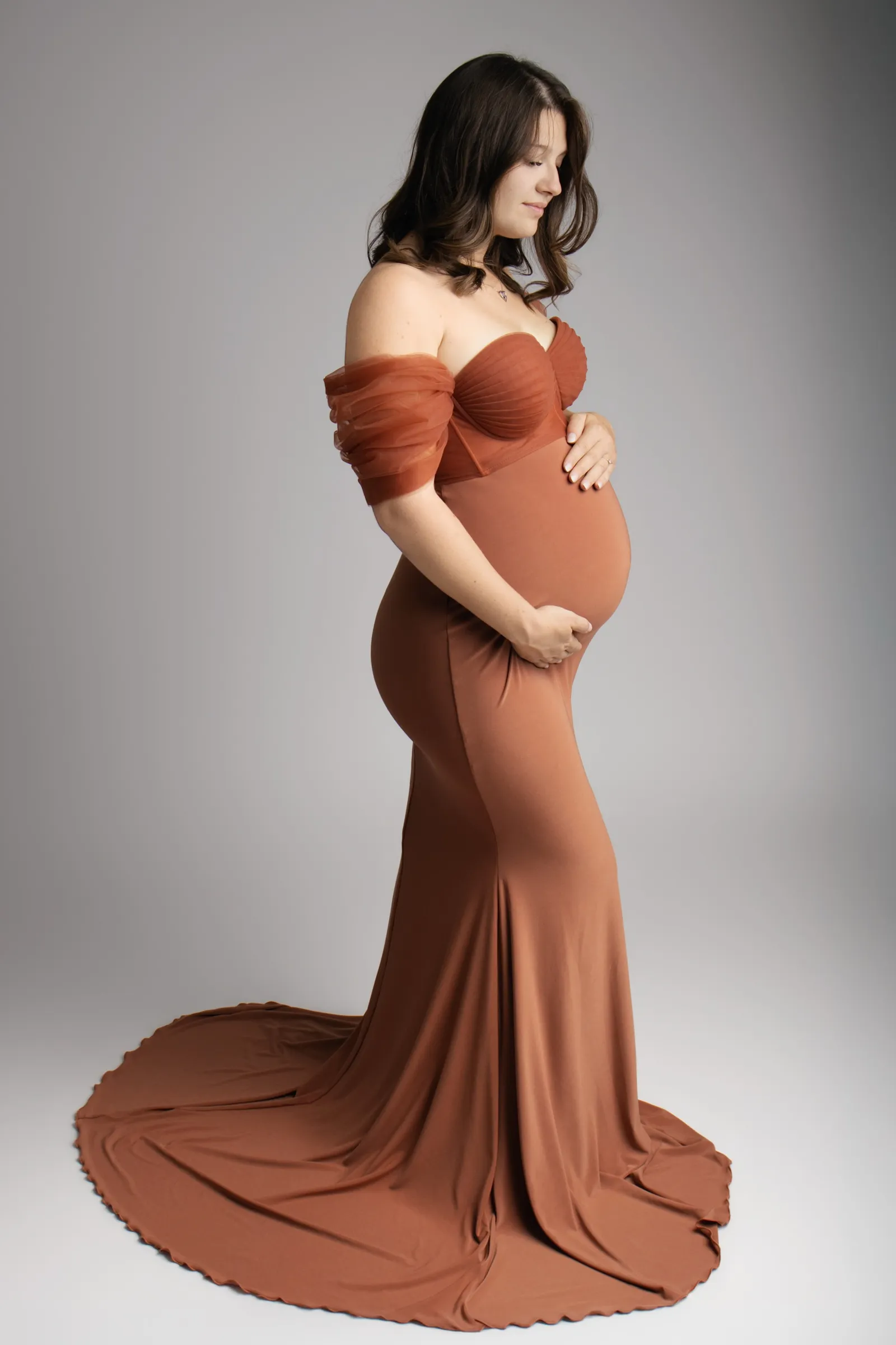 Femme enceinte en robe longue terracotta à manches de tulle, portrait maternité en studio - Cindy Poulet photographe