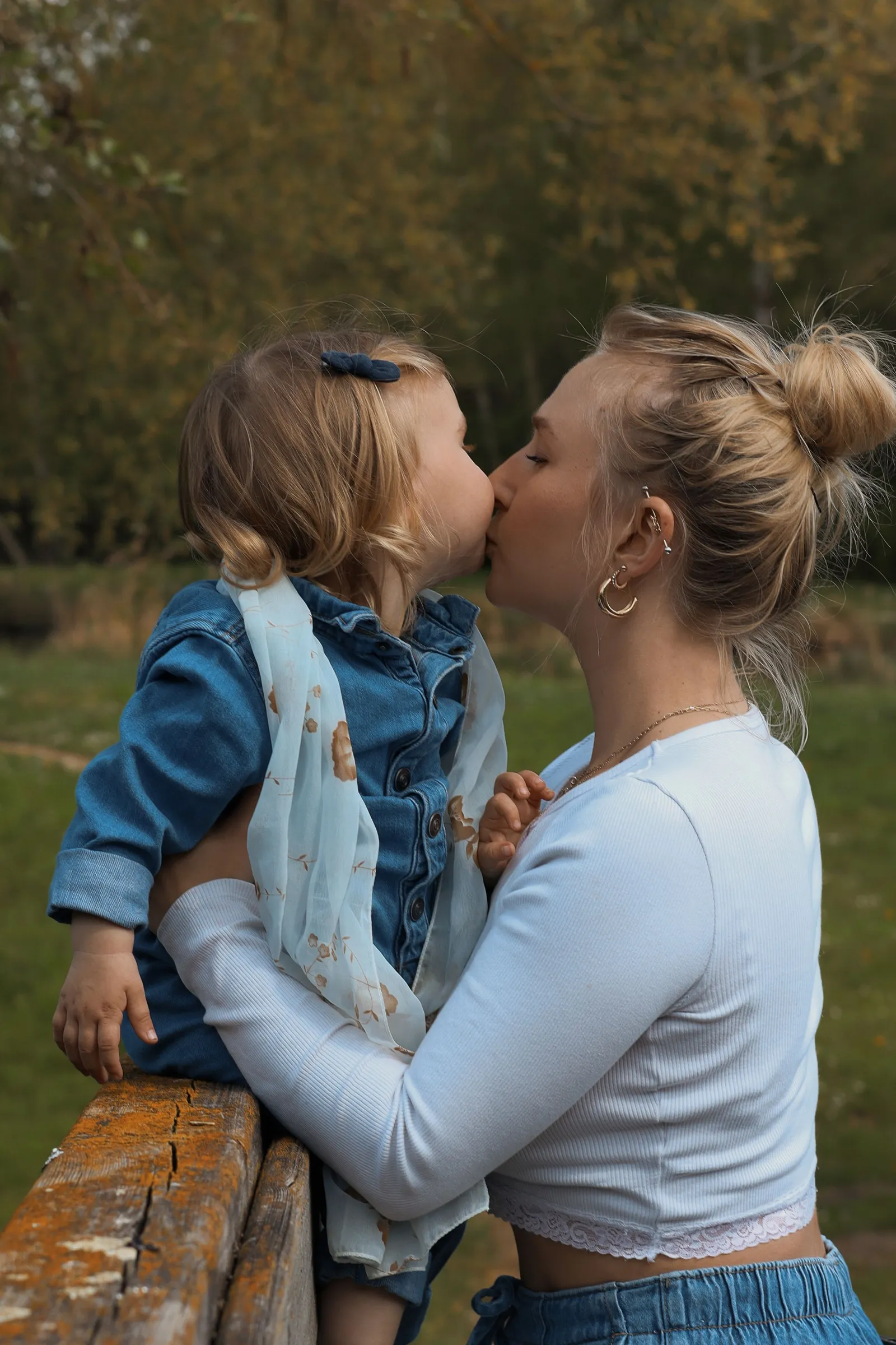 Maman embrassant son bébé dans les bras dans un parc en automne - Cindy Poulet photographe