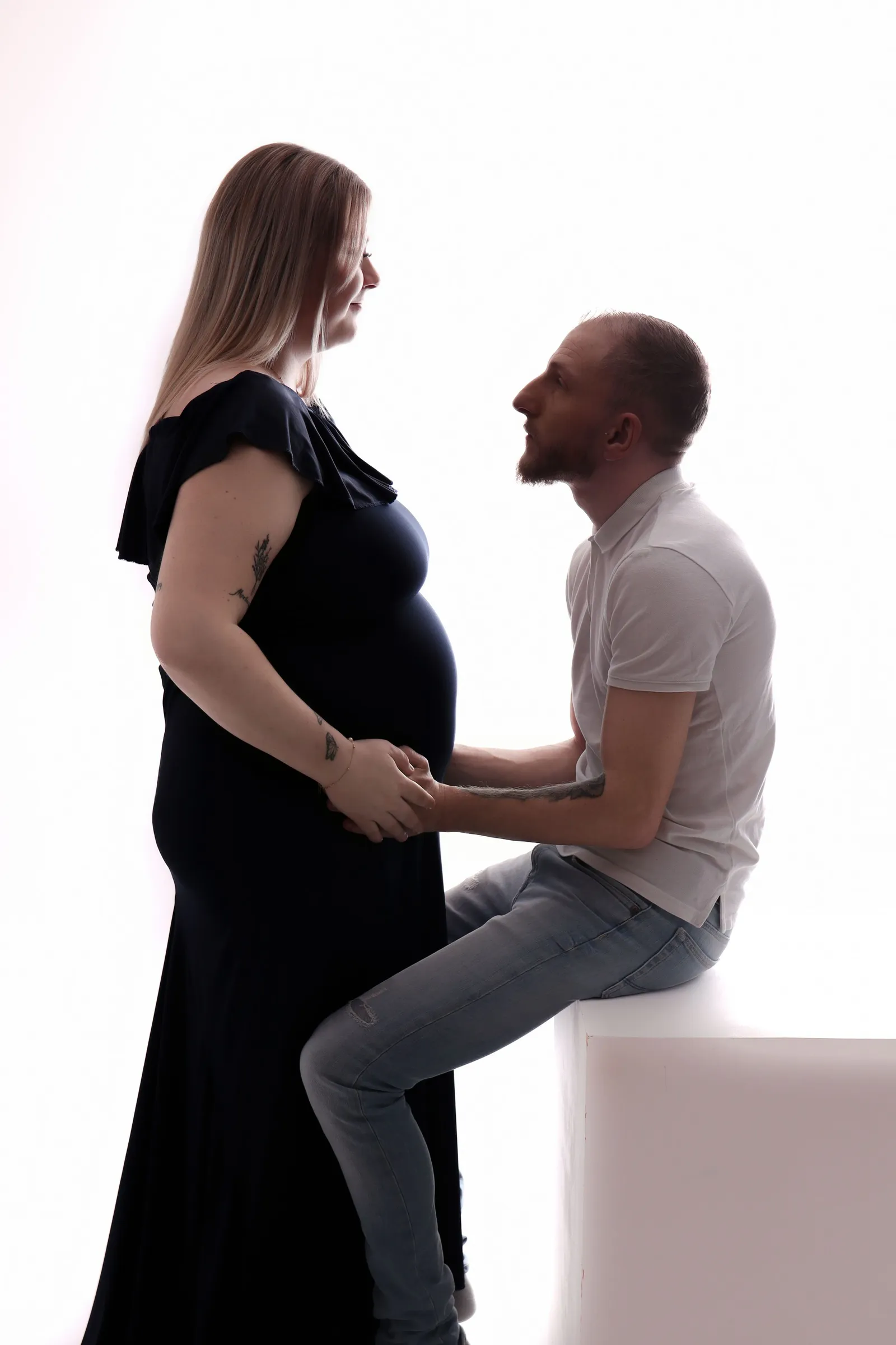 Couple avec femme enceinte se regardant tendrement en studio
