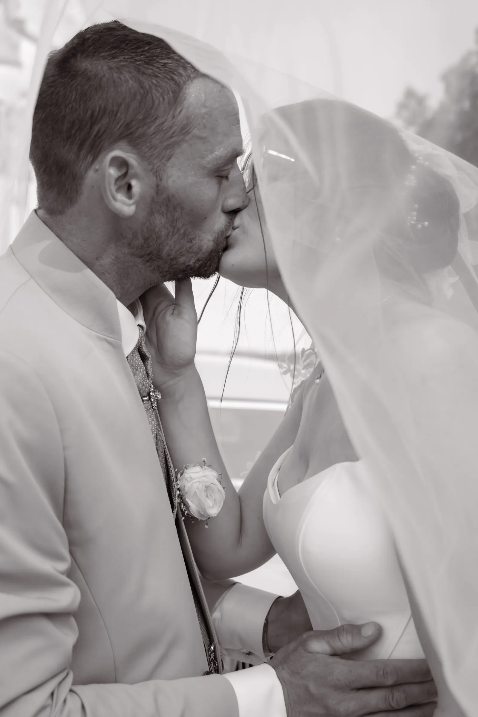 Les mariés s'embrassant sous le voile, portrait en noir et blanc - Cindy Poulet photographe
