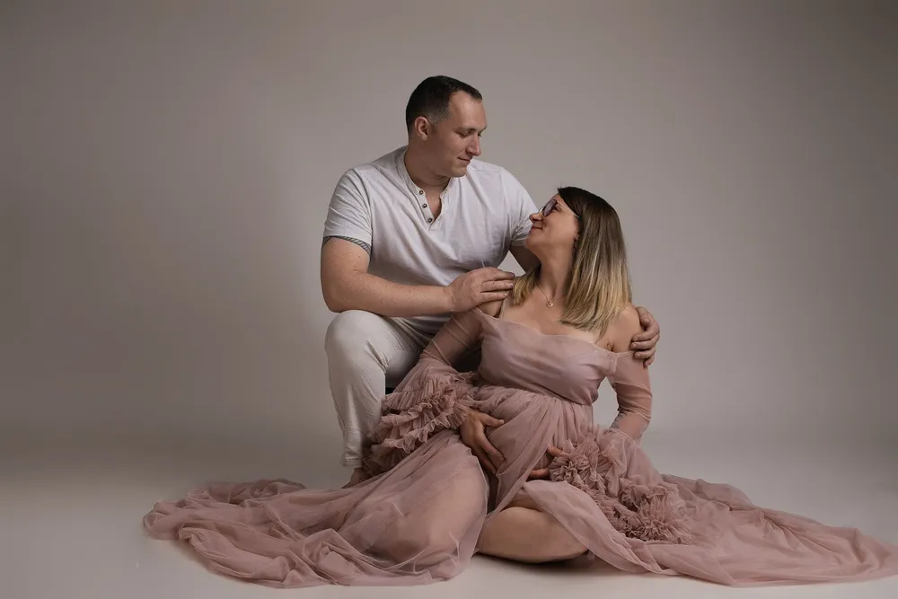 Couple en studio, la future maman en robe de tulle rose, séance grossesse - Cindy Poulet photographe