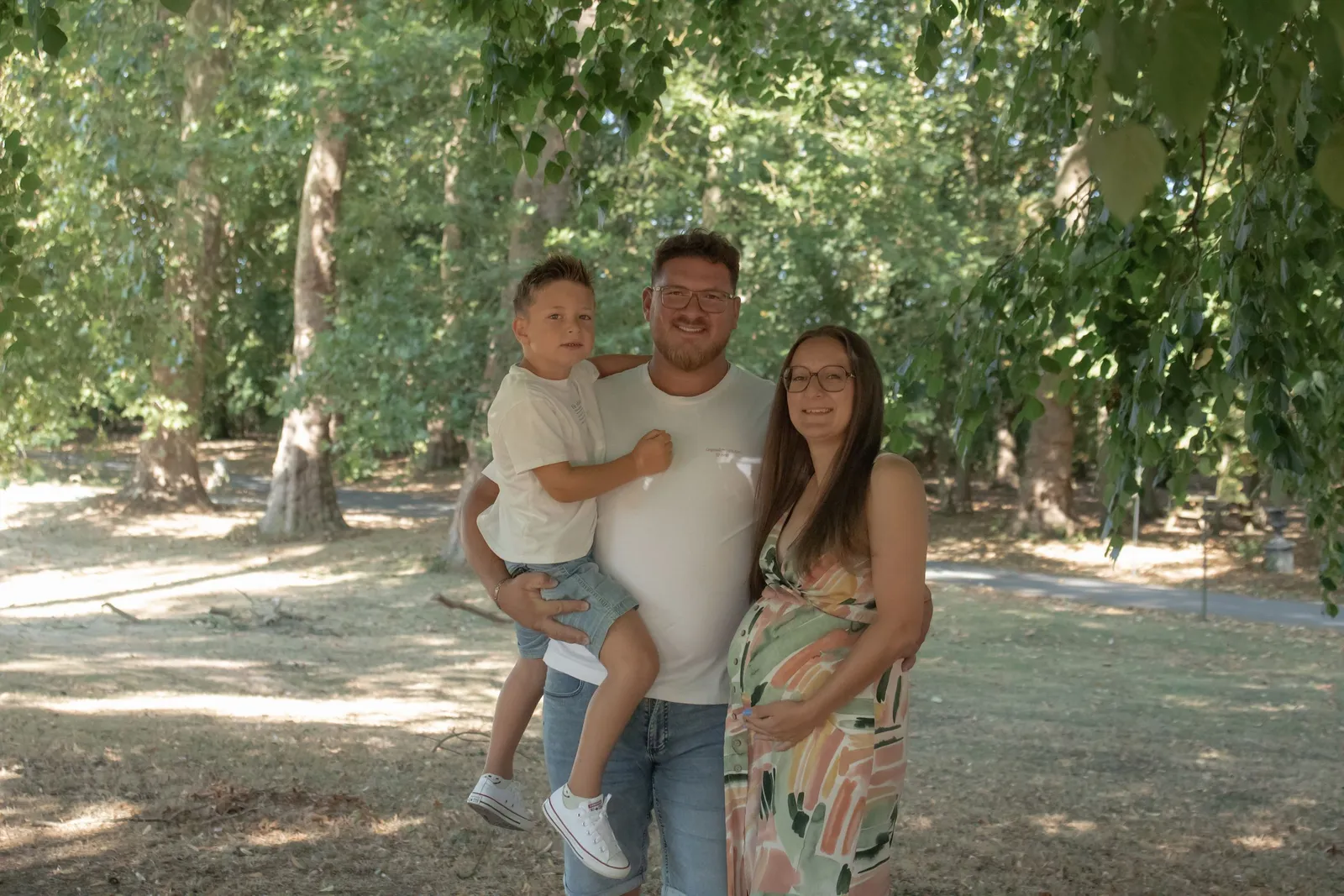 Parents et leur petit garçon dans les bras de son papa, portrait de famille en extérieur - Cindy Poulet photographe