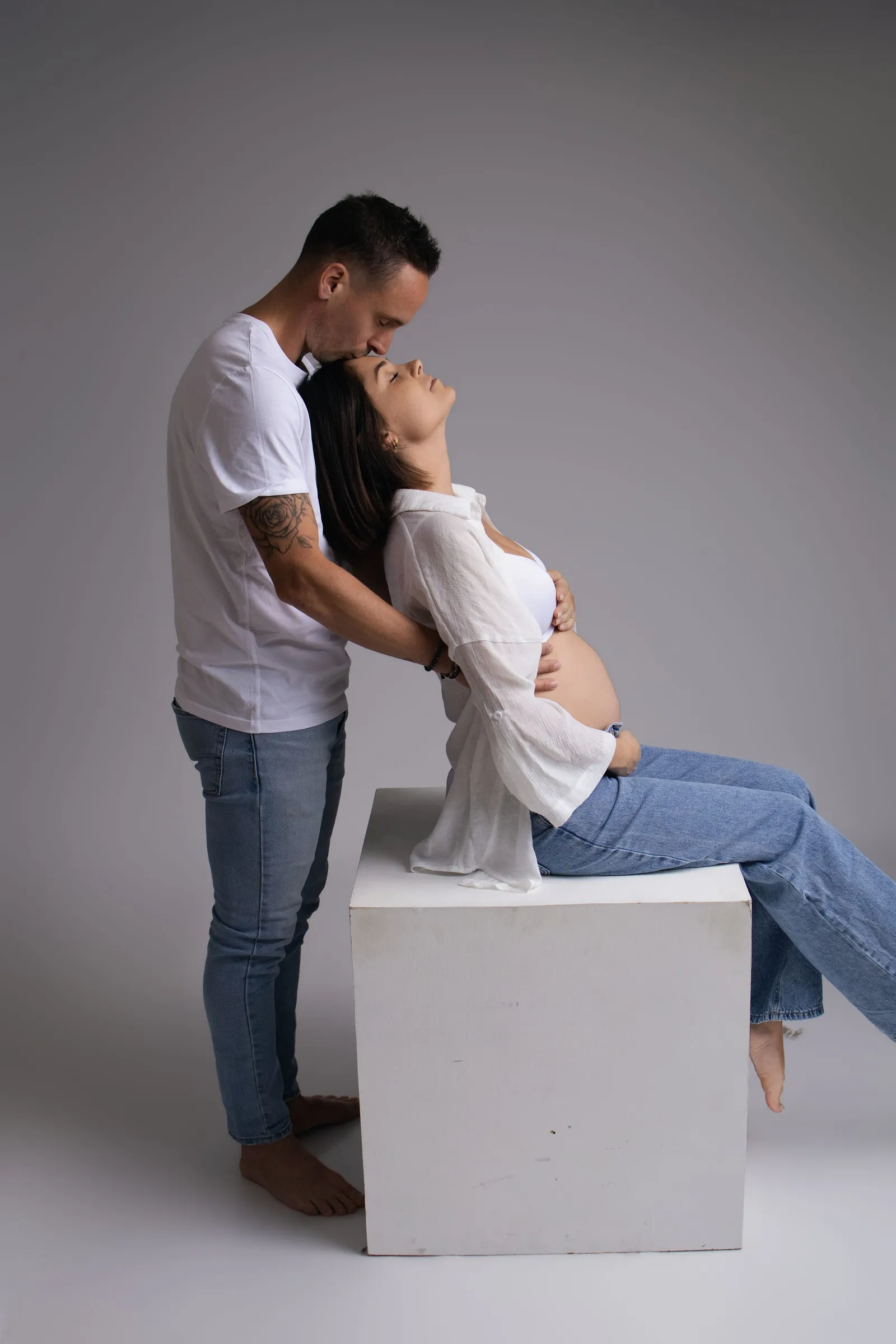 Photo de grossesse complice : futur papa regardant le ventre de la maman. Séance maternité par Cindy Poulet à Septvaux, près de Laon.